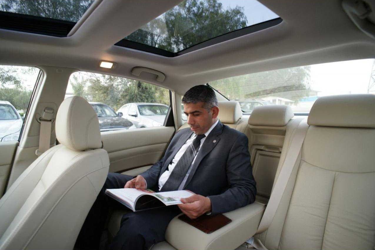 Executive relaxing in the leather rear cabin of a RAO Limousine chauffeured car